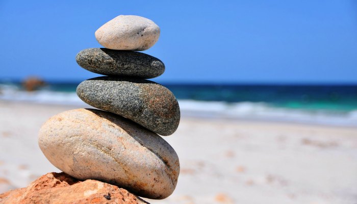 rocks stacked up in a tower on a sandy beach