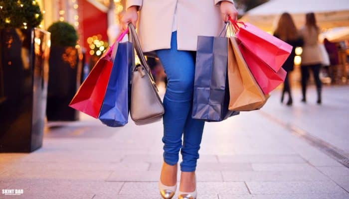 A woman walking down a British high street holding shopping bags, representing a simple mystery shopping trip.