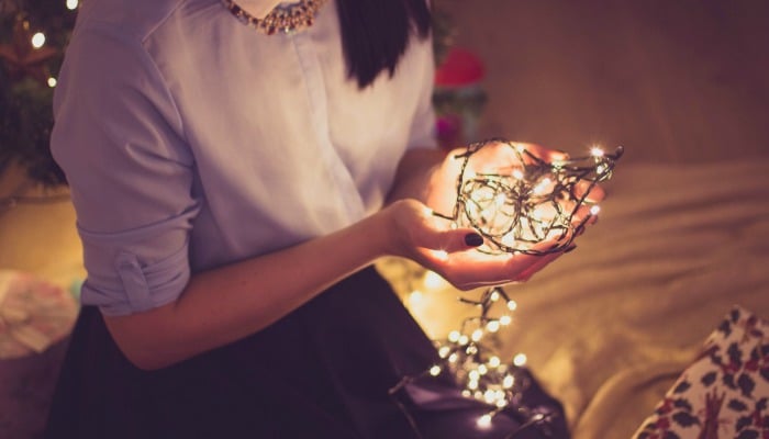 woman holding Christmas tree lights