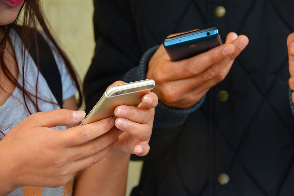 close up of two people using their phones