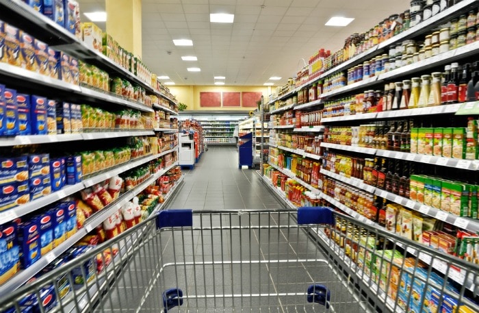 An empty cart between shelves in the supermarket.