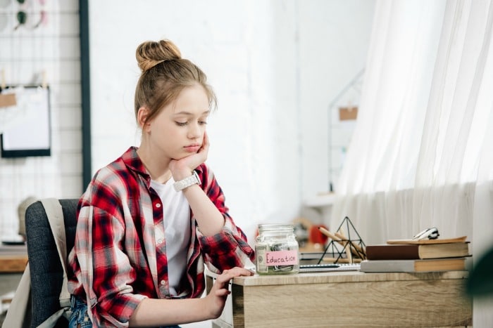 sad teenager with money pot