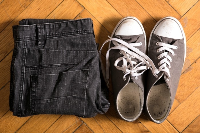 Grey sneakers and jeans on the floor.