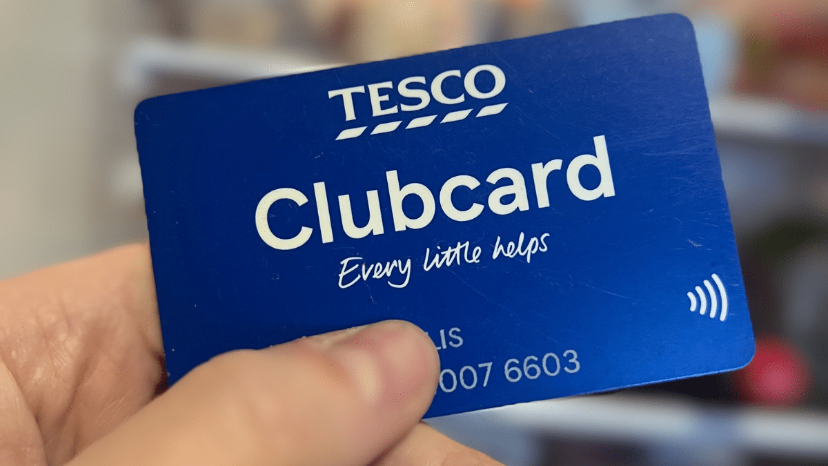 holding a Tesco Clubcard in from of a fridge
