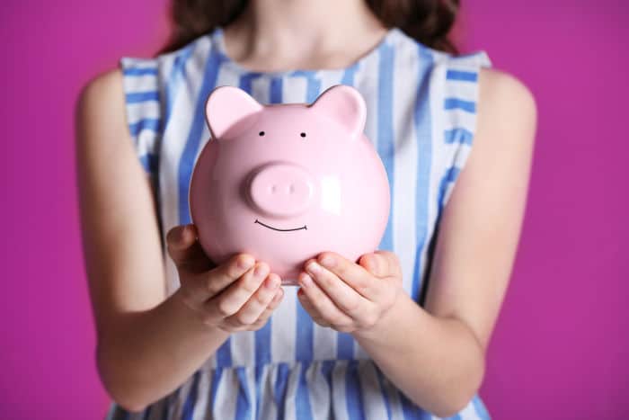 girl holding a piggy bank