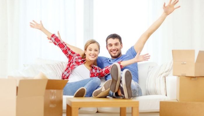 Smiling couple relaxing on sofa in new home