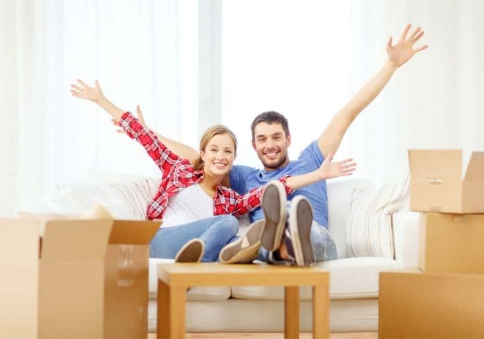 Smiling couple relaxing on sofa in new home