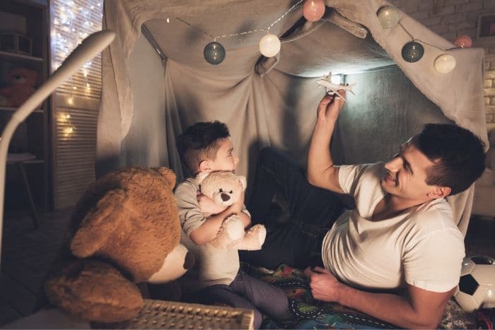 father and son in blanket fort