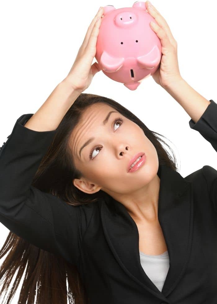 woman looking for money in piggy bank