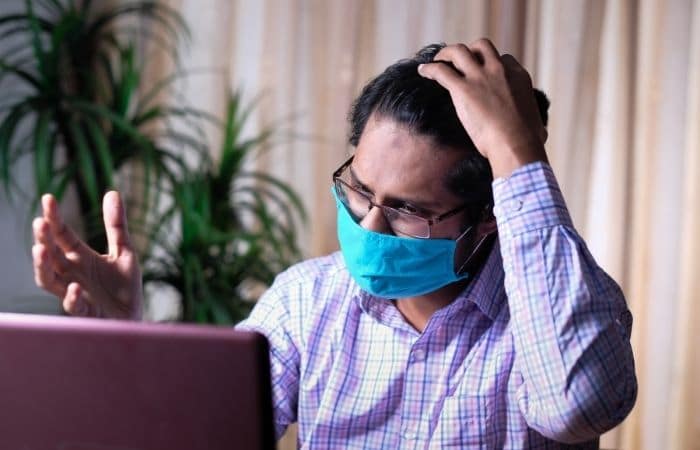 Man wearing mask using laptop