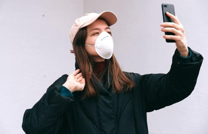 Woman wearing mask holding phone