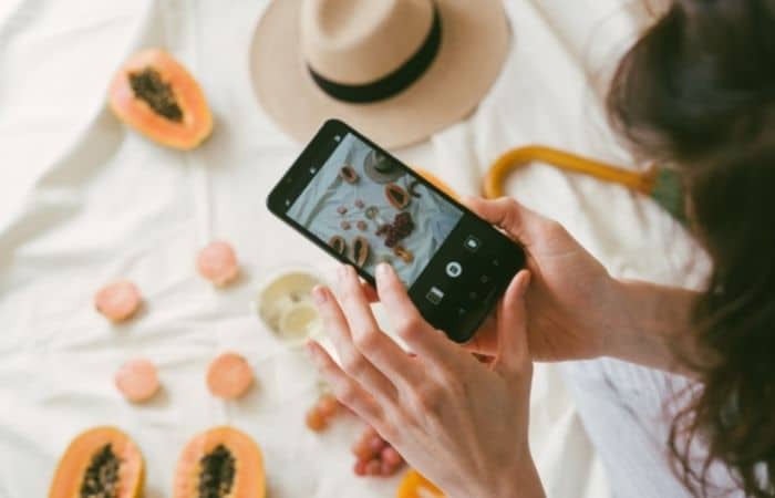 mujer tomando fotos con teléfono