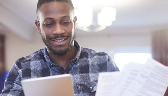 Man smiling while looking at energy bills