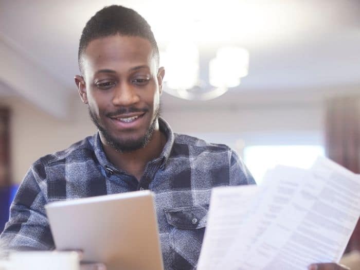 Man smiling while looking at energy bills