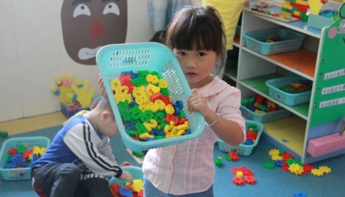 young girl holding basket of number magnets