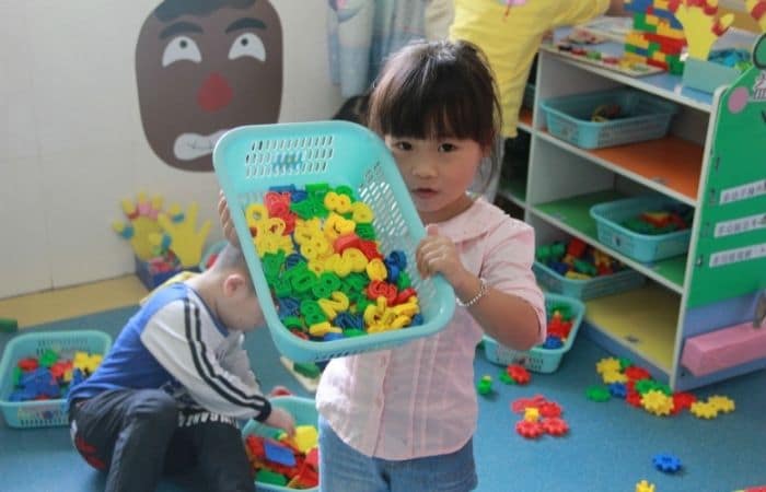 young girl holding basket of number magnets