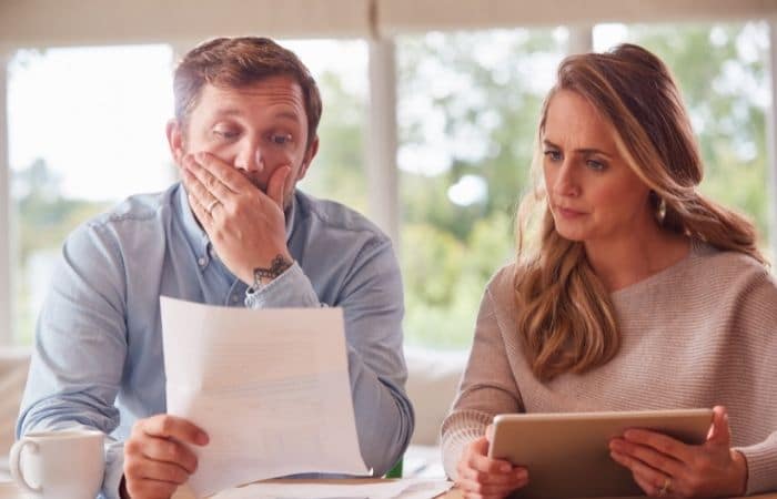 couple concerned looking at paperwork