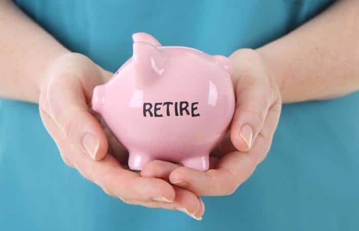 hands holding a piggy bank with with the word retire written on it