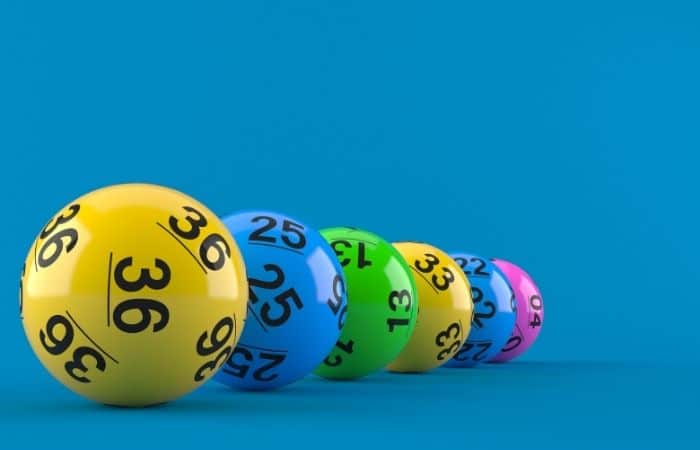 Brightly coloured lottery balls in a row on a blue background