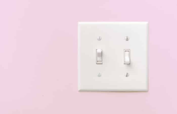 dual light switch on a pink wall