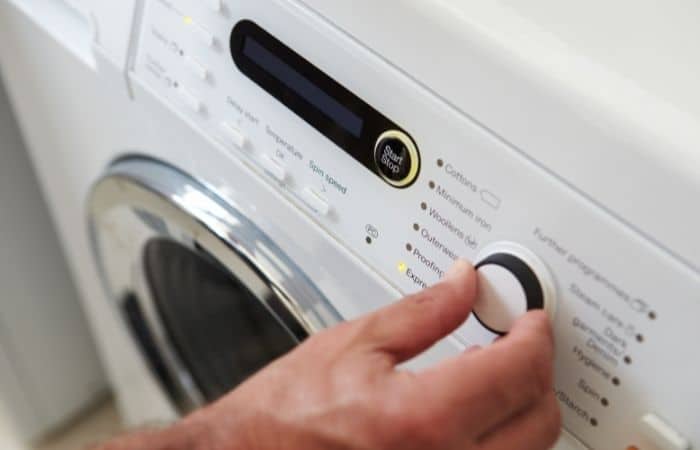 hand adjusting washing machine dial
