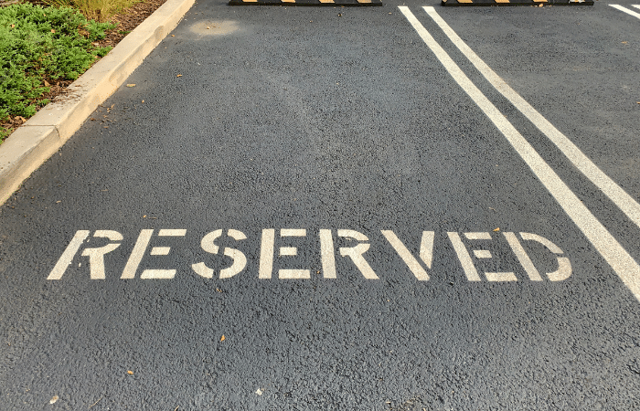 parking space with the words reserved painted on the tarmac