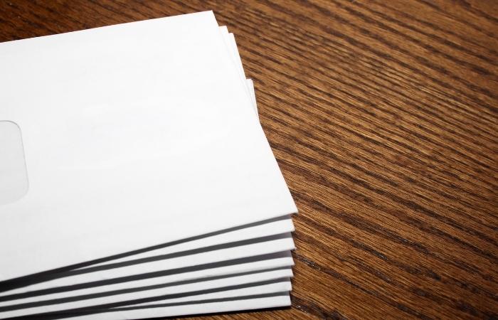 stack of envelopes on wooden desk