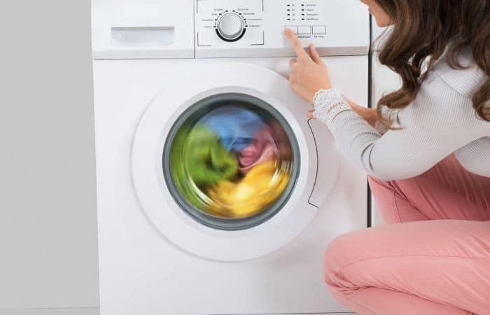 woman looking at a full washing machine