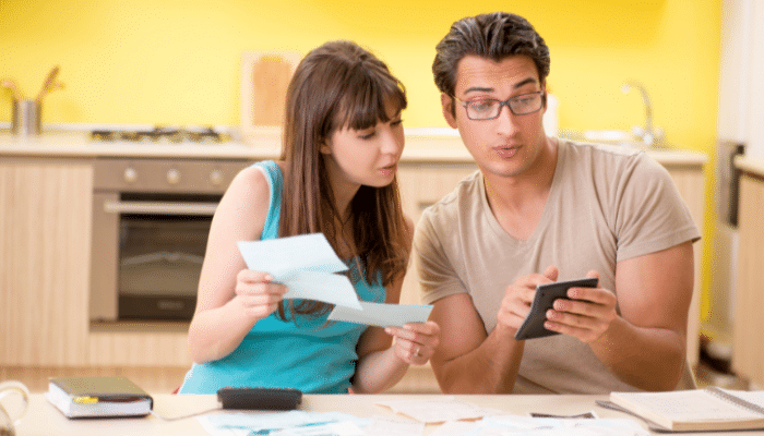 couple looking at bills and calculator