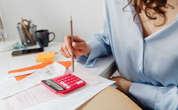 A Woman Computing Bills while Holding a Pencil