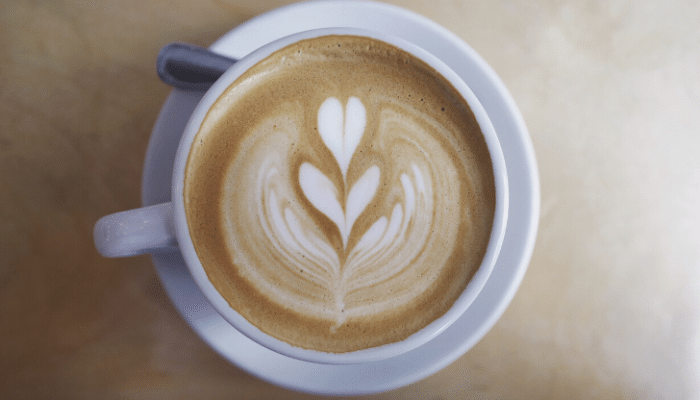 overhead view of cappuccino with milk art heart patterns