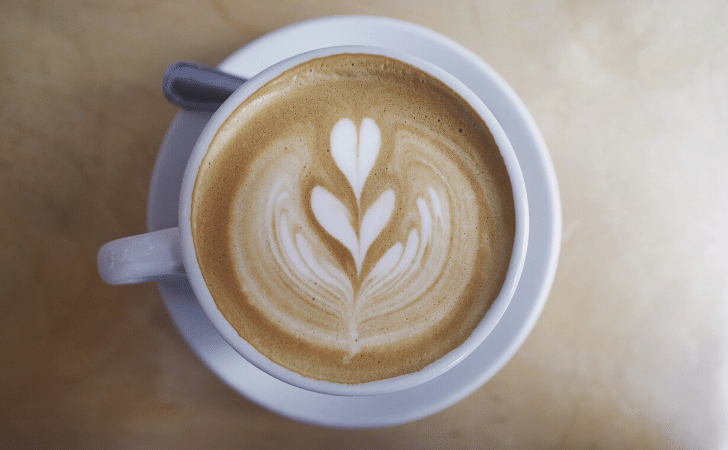 overhead view of cappuccino with milk art heart patterns