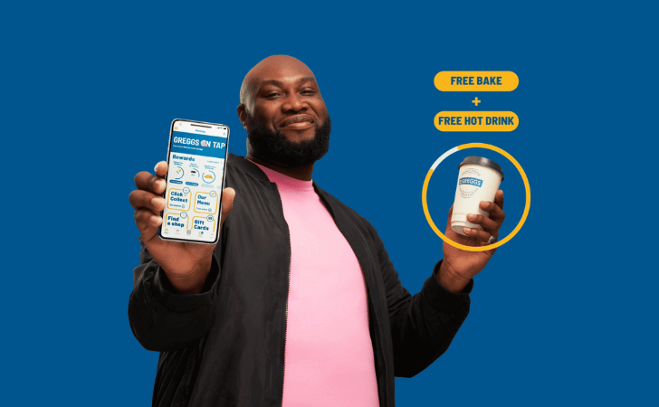 man holding greggs app holding a coffee with the words free greggs