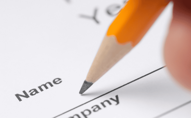 Close up of a pencil writing name on a piece of paper