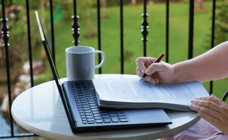 person working outside on laptop and papers