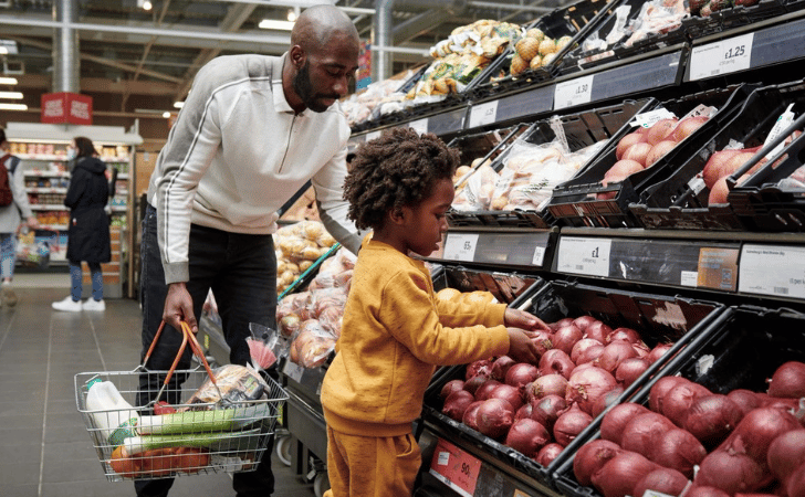 father and child shopping for vegetables in Sainsbury's