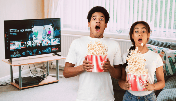 shocked couple with popcorn watching netflix