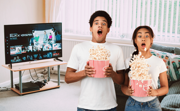 shocked couple with popcorn watching netflix