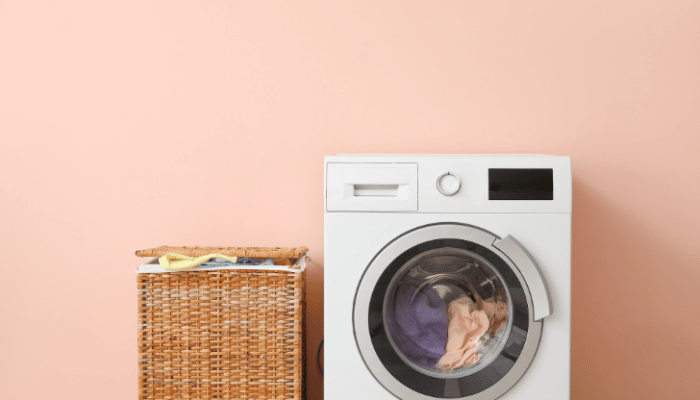 washing machine against peach wall