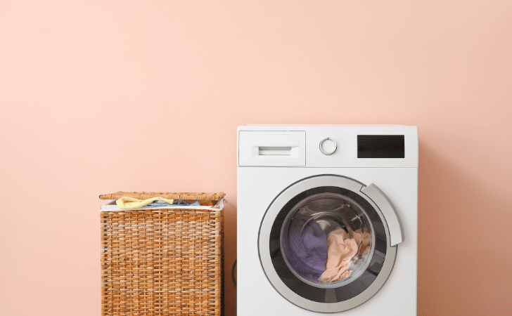 washing machine against peach wall