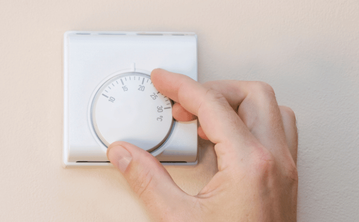 hand on thermostat