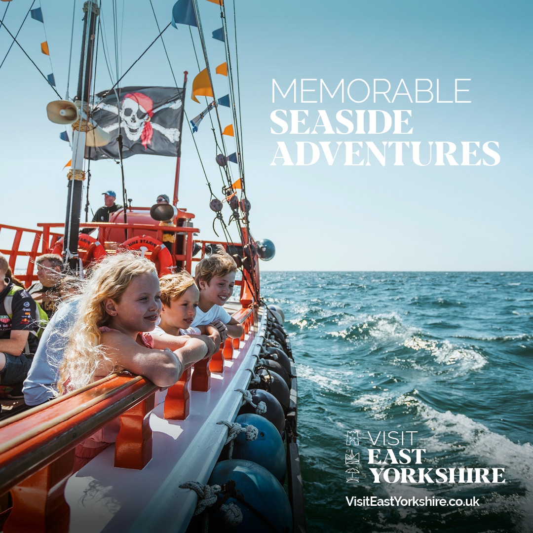 children looking over the side of a pirate ship, with the words "memorable seaside adventures" superimposed