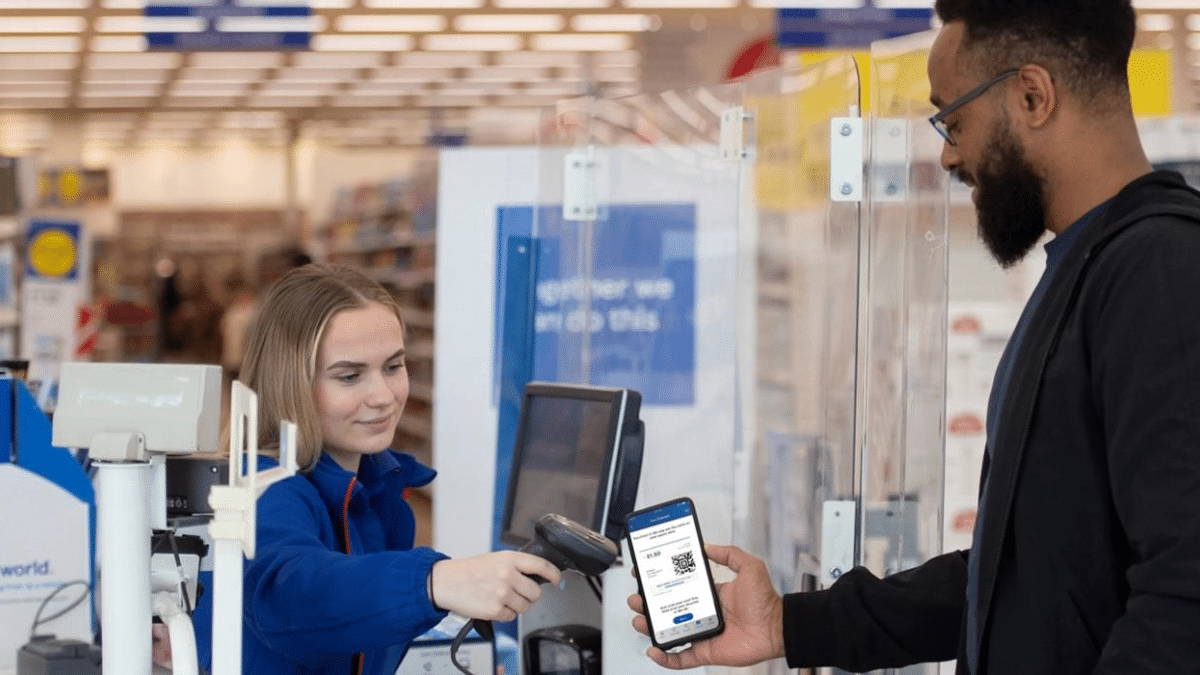 Man showing QR code of Tesco Clubcard while at the till