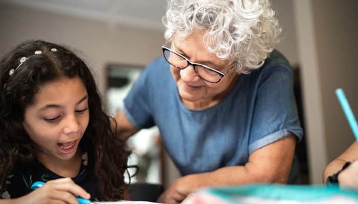 Photo of an older lady tutoring a child