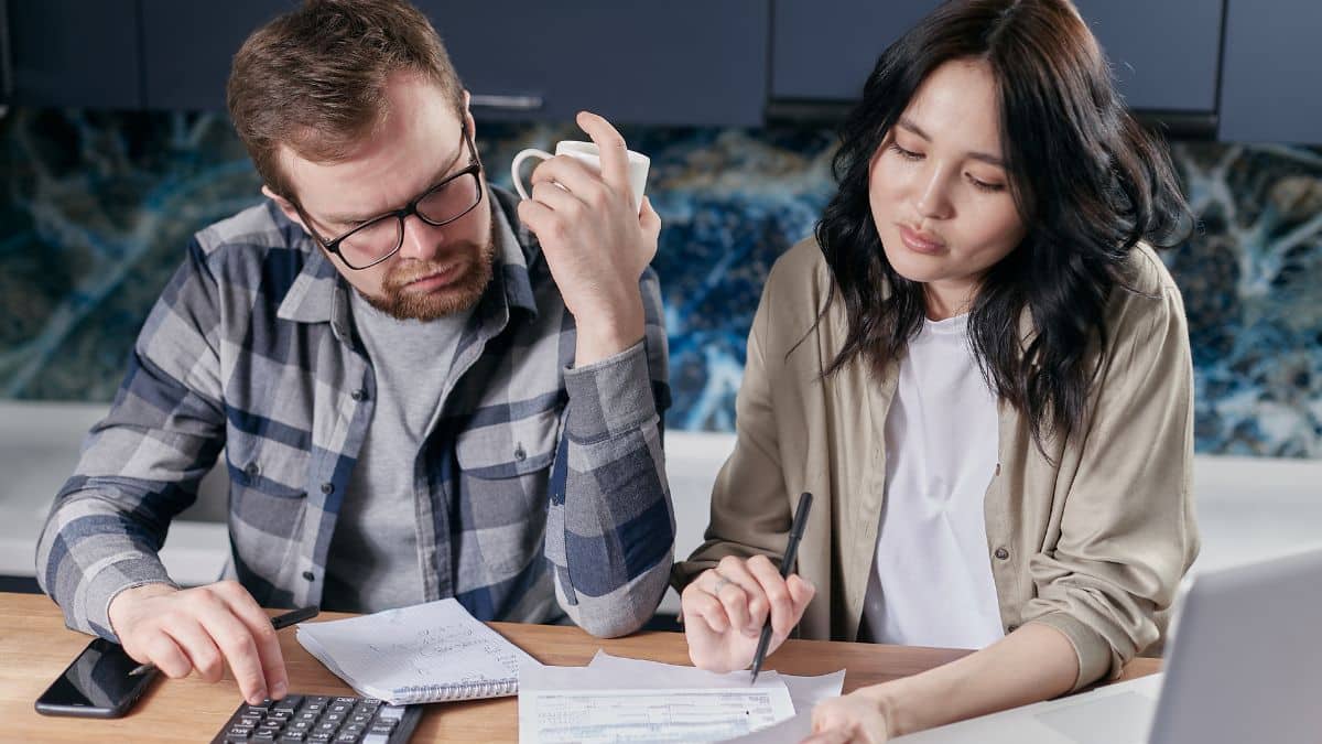 A couple sitting at the table looking at paperwork