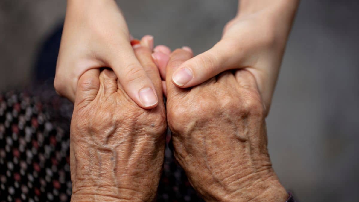 Child holding hands with elderly parent