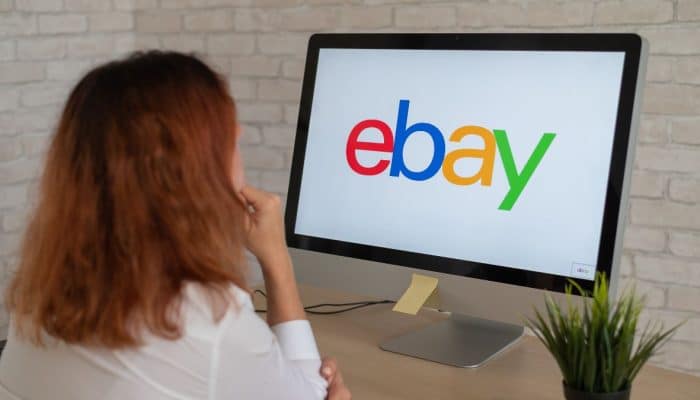 Woman looking at the eBay logo on a computer screen.