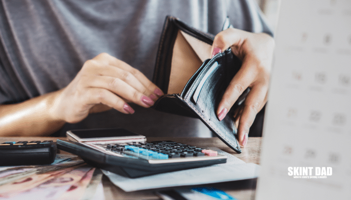 A Woman's Hand open an Empty Purse for Money