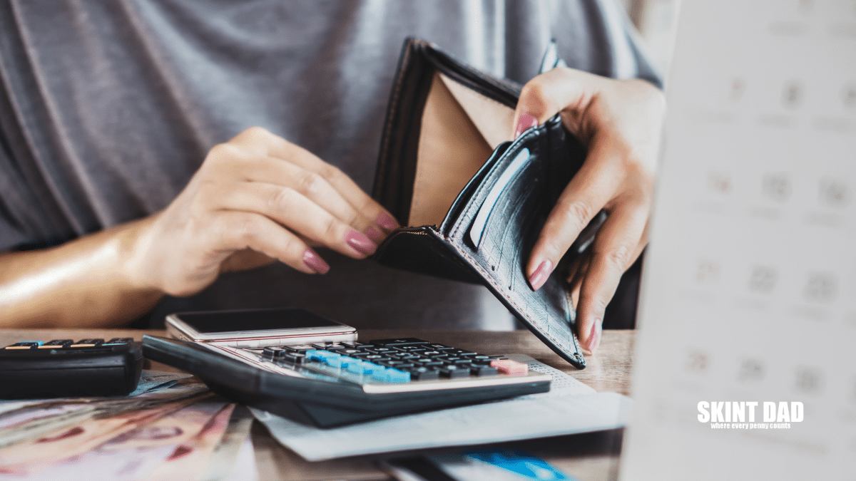A Woman's Hand open an Empty Purse for Money