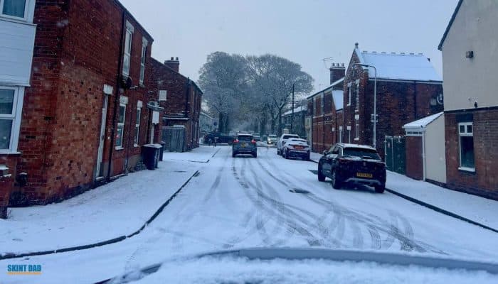 UK residential street covered in snow, showing freezing weather conditions linked to Cold Weather Payments.